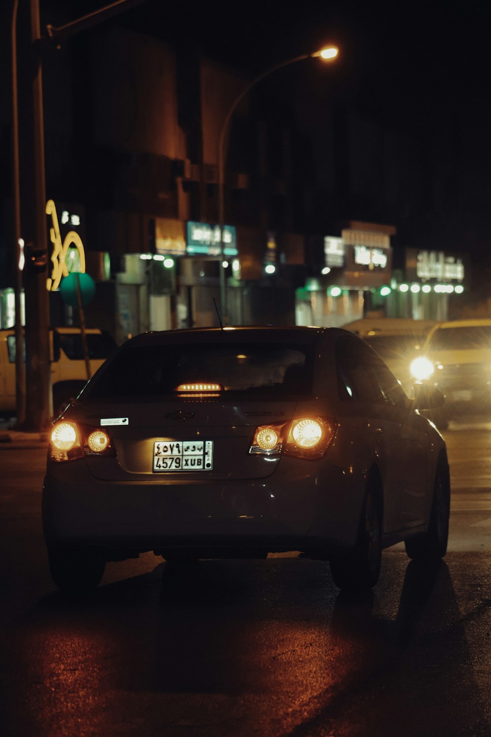 a car driving down a street at night