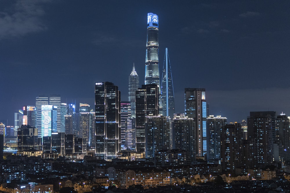 a city skyline at night with skyscrapers lit up