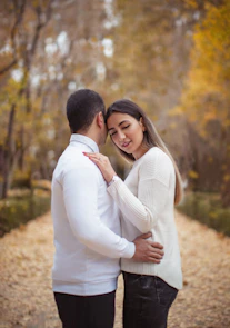 a man and a woman standing together in the woods