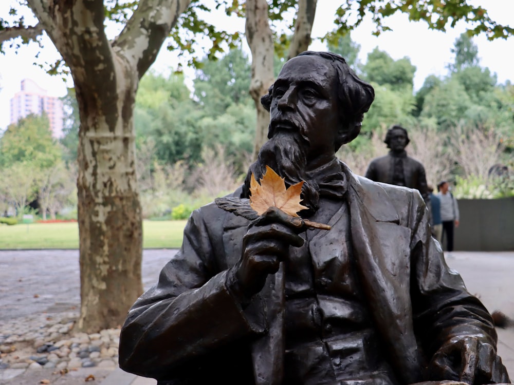 a statue of a man holding a leaf