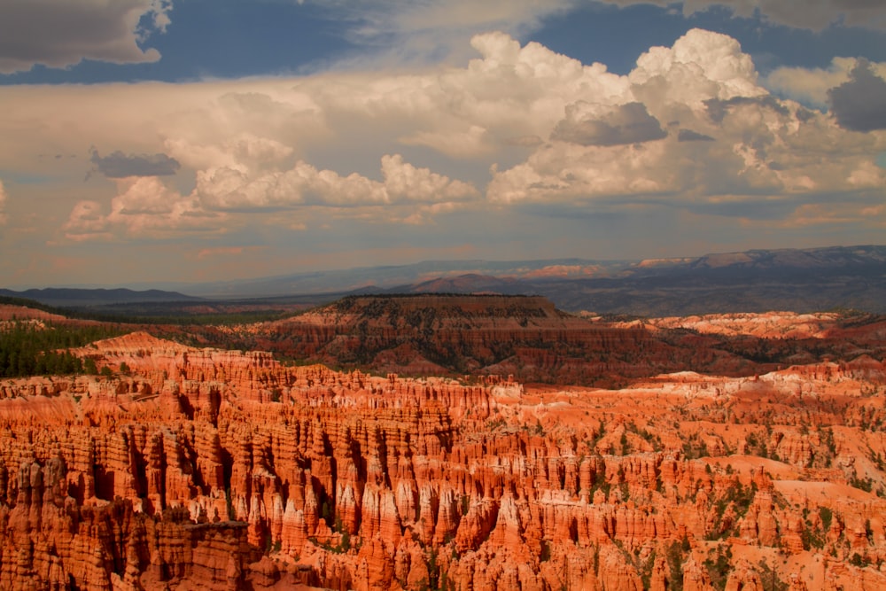 a group of clouds in a canyon with Bryce Canyon National Park in the background