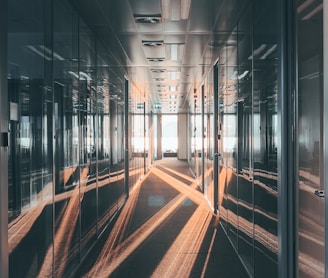 a long hallway with mirrored walls and light coming through the windows