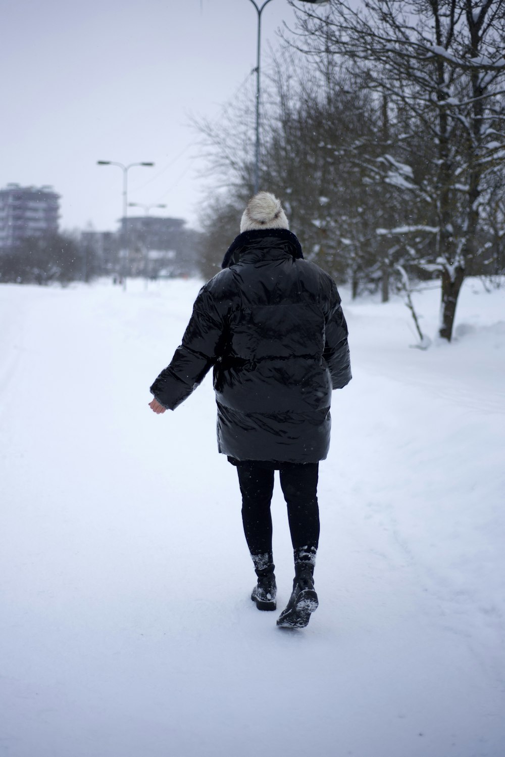 Eine Person, die in einem Parka im Schnee spazieren geht