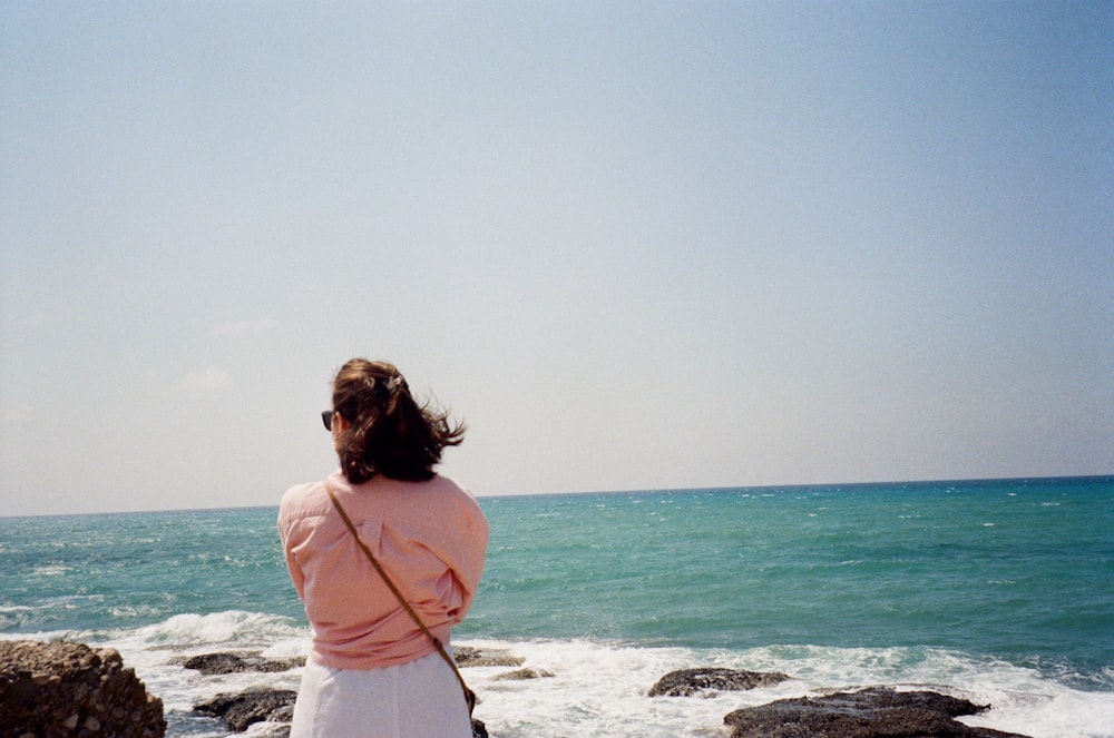 a woman flying a kite on the beach