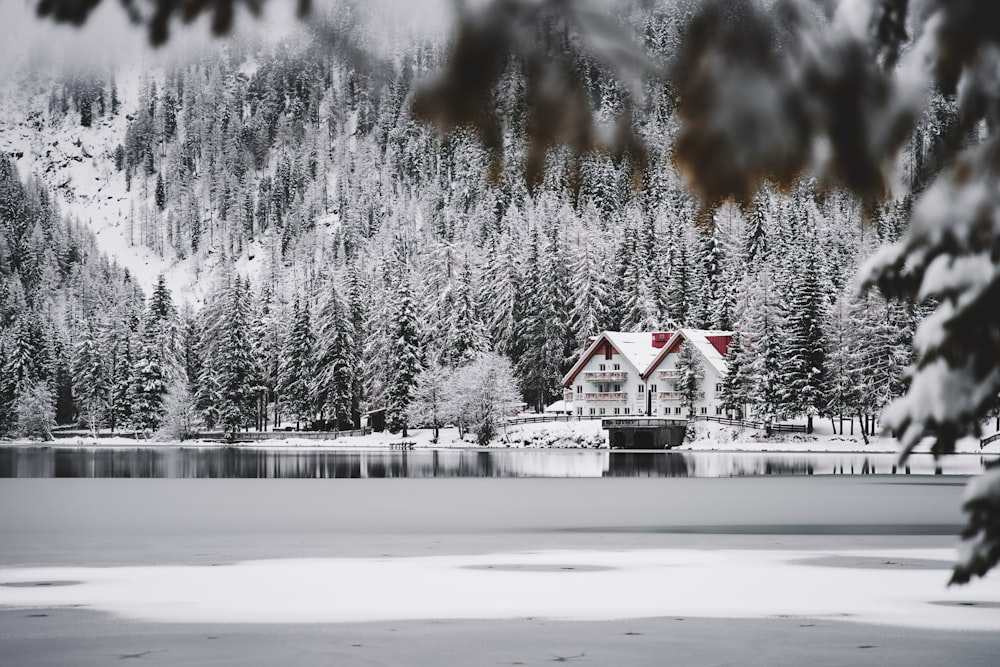 a house sitting on top of a lake covered in snow