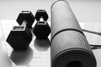 a black and white photo of dumbbells and a yoga mat