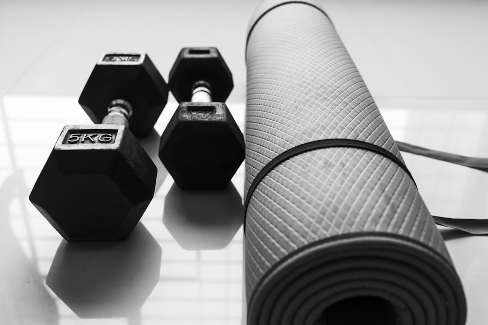 a black and white photo of dumbbells and a yoga mat