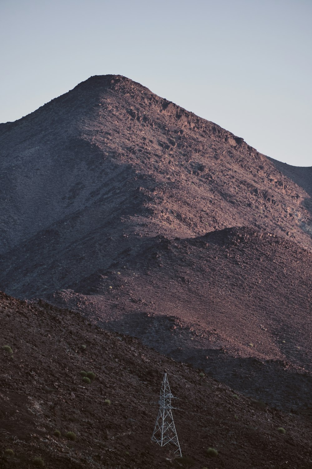 una montaña con un poste de teléfono en primer plano