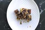 a white plate topped with brownies and nuts