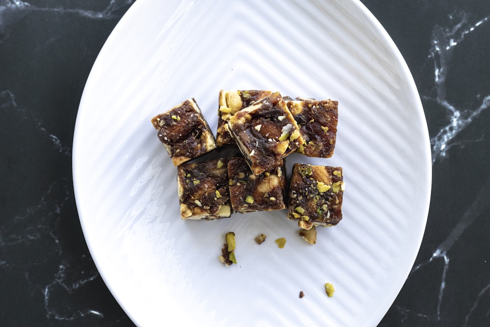 a white plate topped with brownies and nuts