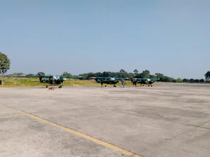Technicians performing maintenance checks on a helipad surface under clear skies.