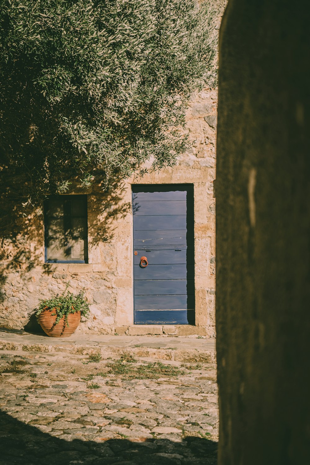 a stone building with a blue door and window