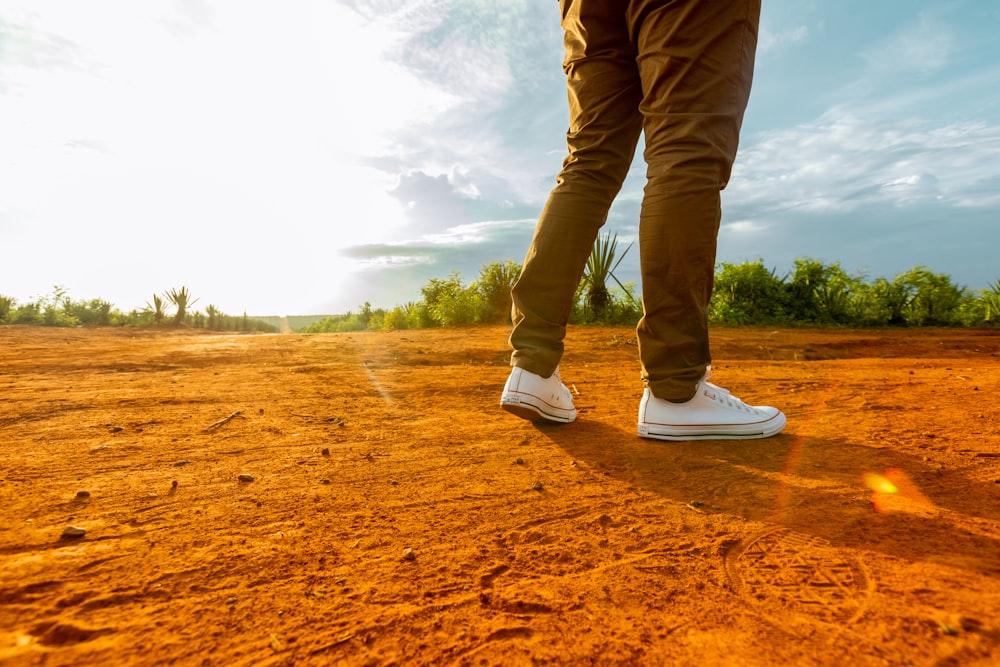 a person standing in the middle of a dirt field