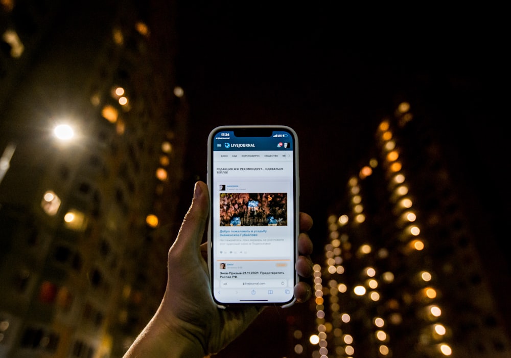 a person holding a cell phone in their hand