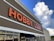 A large retail store with 'Hobby Lobby' prominently displayed in bold orange letters on the building facade. The design features a clean, modern look under a partly cloudy sky.