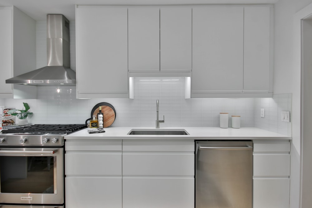 a kitchen with white cabinets and stainless steel appliances