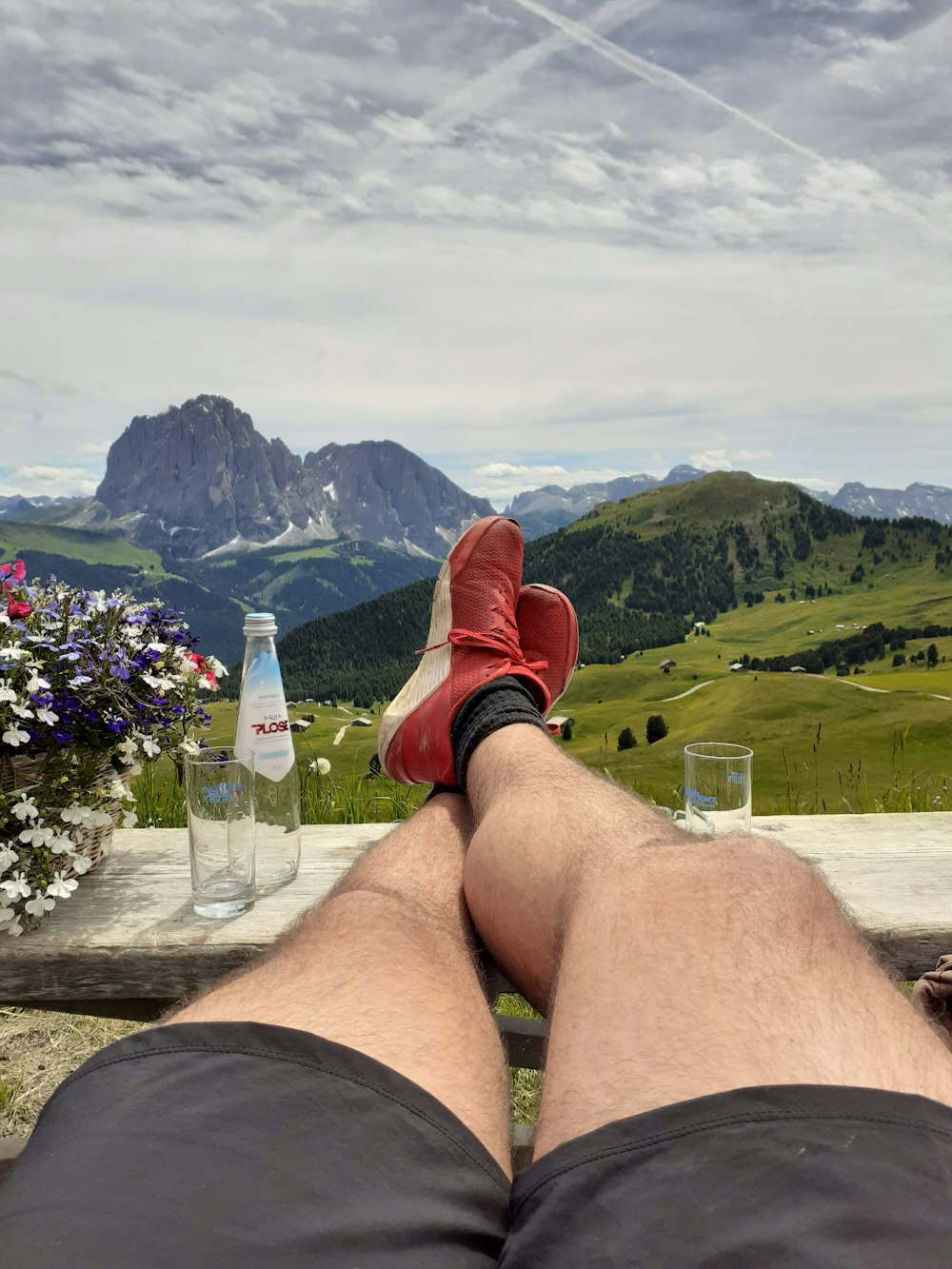 a person sitting on a bench with their feet up