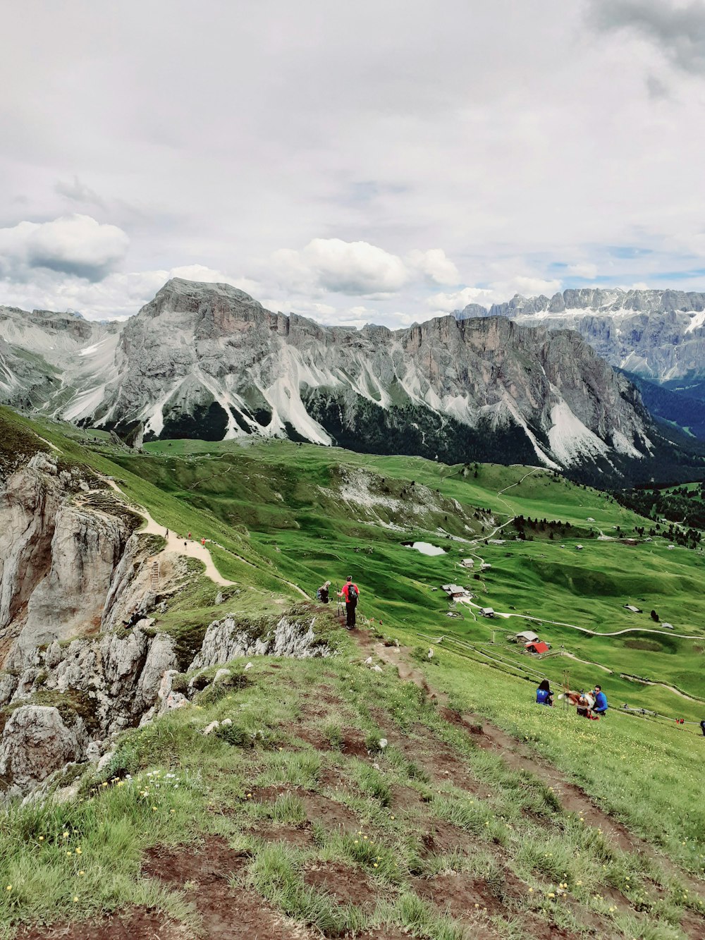 a group of people standing on top of a lush green hillside