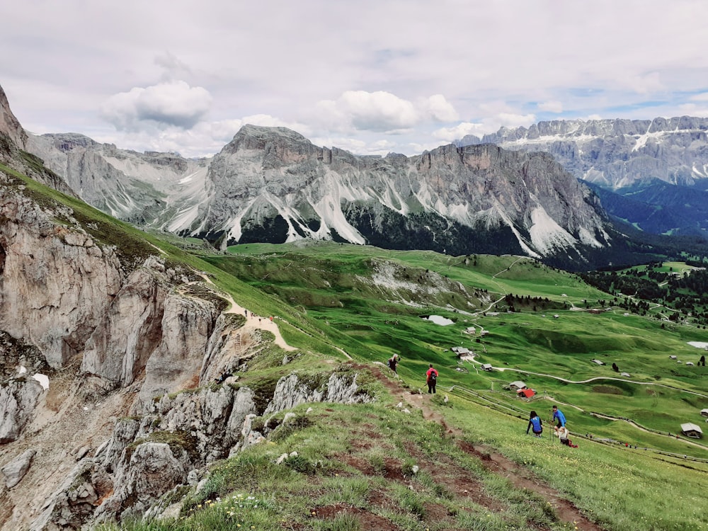 a group of people standing on top of a lush green hillside