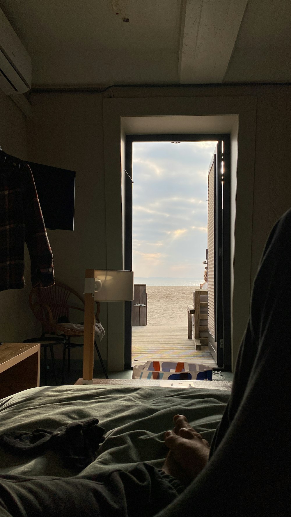 a person laying in a bed with a view of the ocean