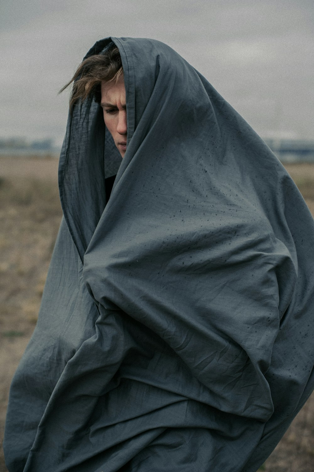 a person wrapped in a blanket in a field