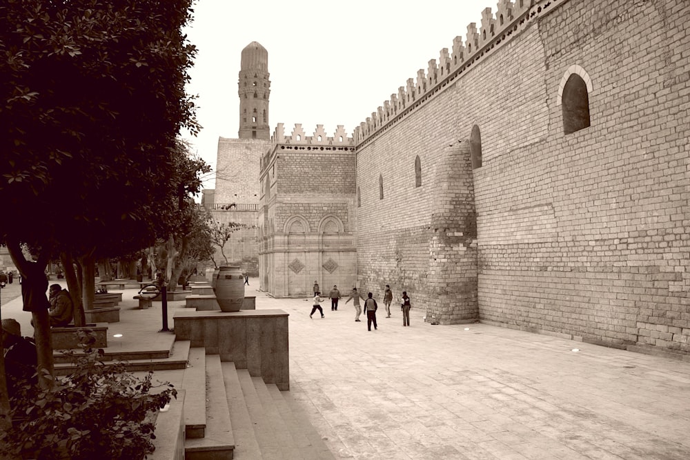 a black and white photo of people walking in a courtyard