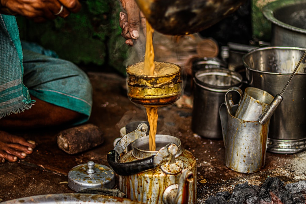 a person pouring something into a pot on a stove