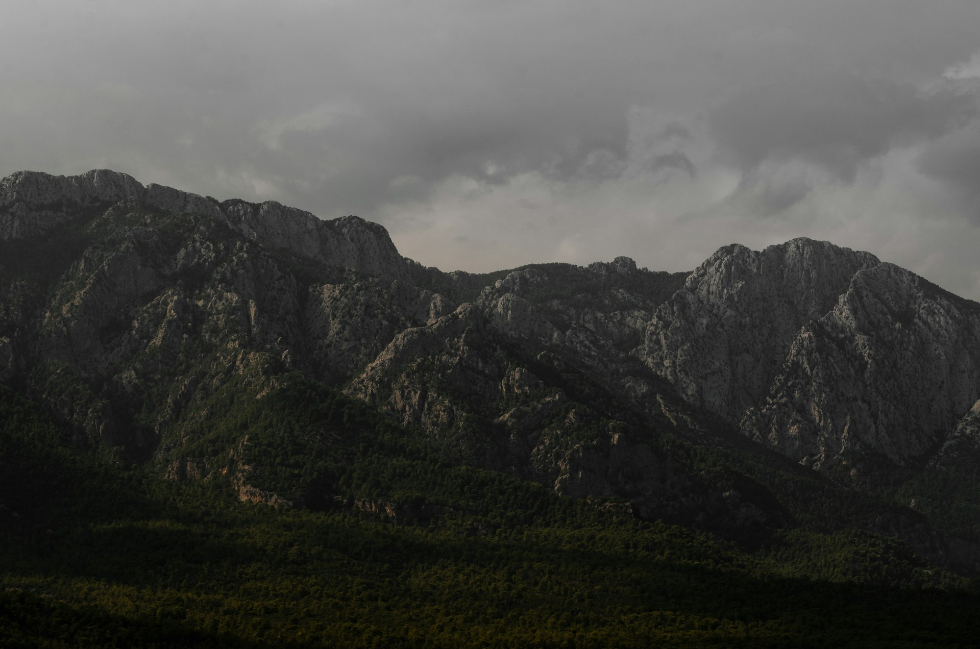a mountain range with a cloudy sky in the background