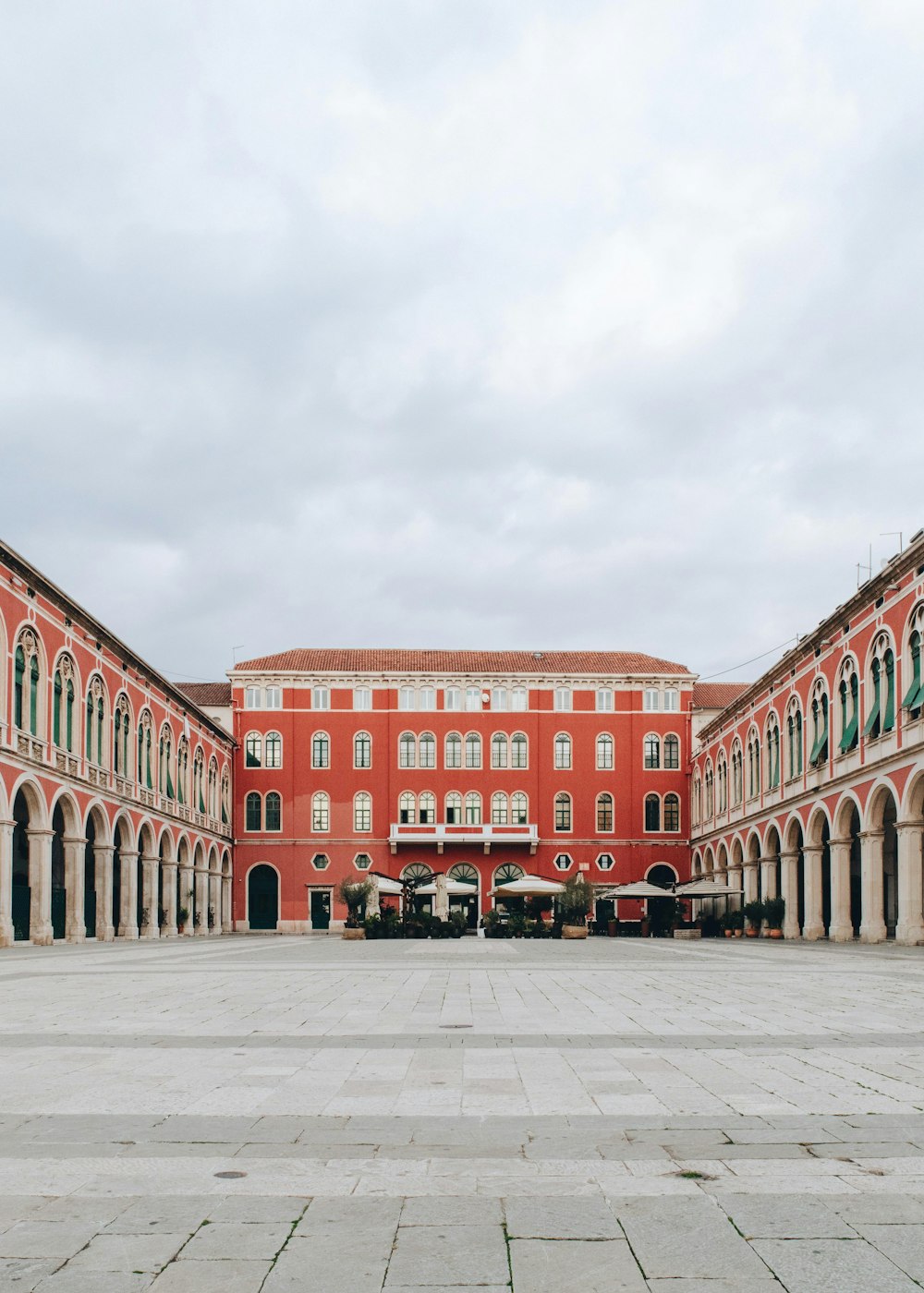 a large red building with arches and a courtyard