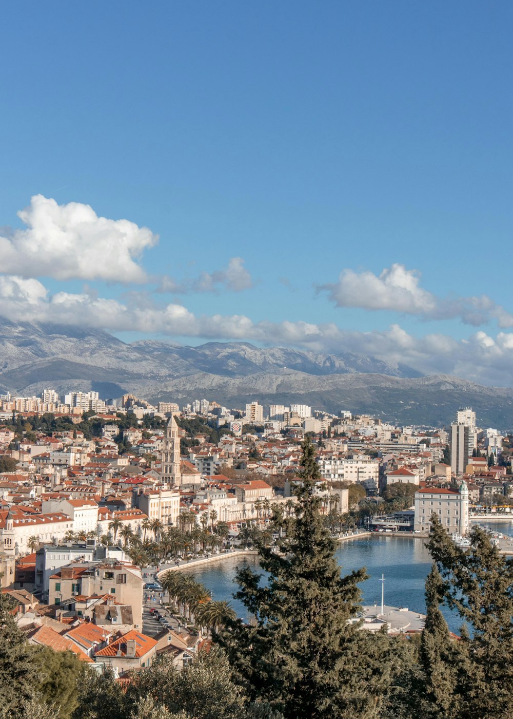 Una vista di una città con un lago e montagne sullo sfondo