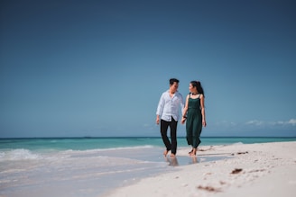 a man and a woman walking on the beach