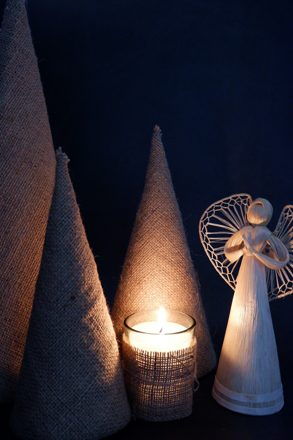 a small angel figurine sitting next to a lit candle