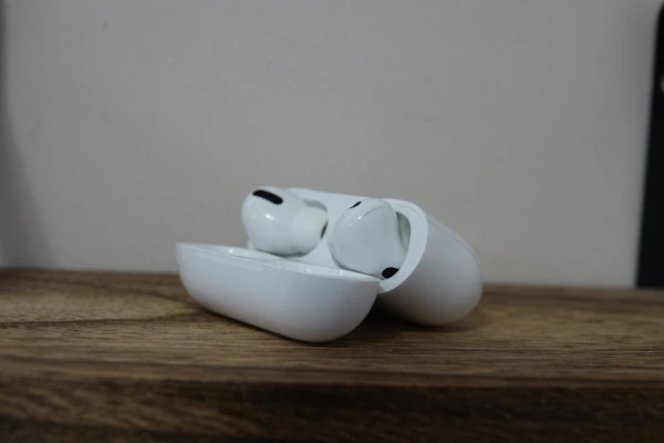 Wireless earbuds resting inside their compact charging case on a marble surface.