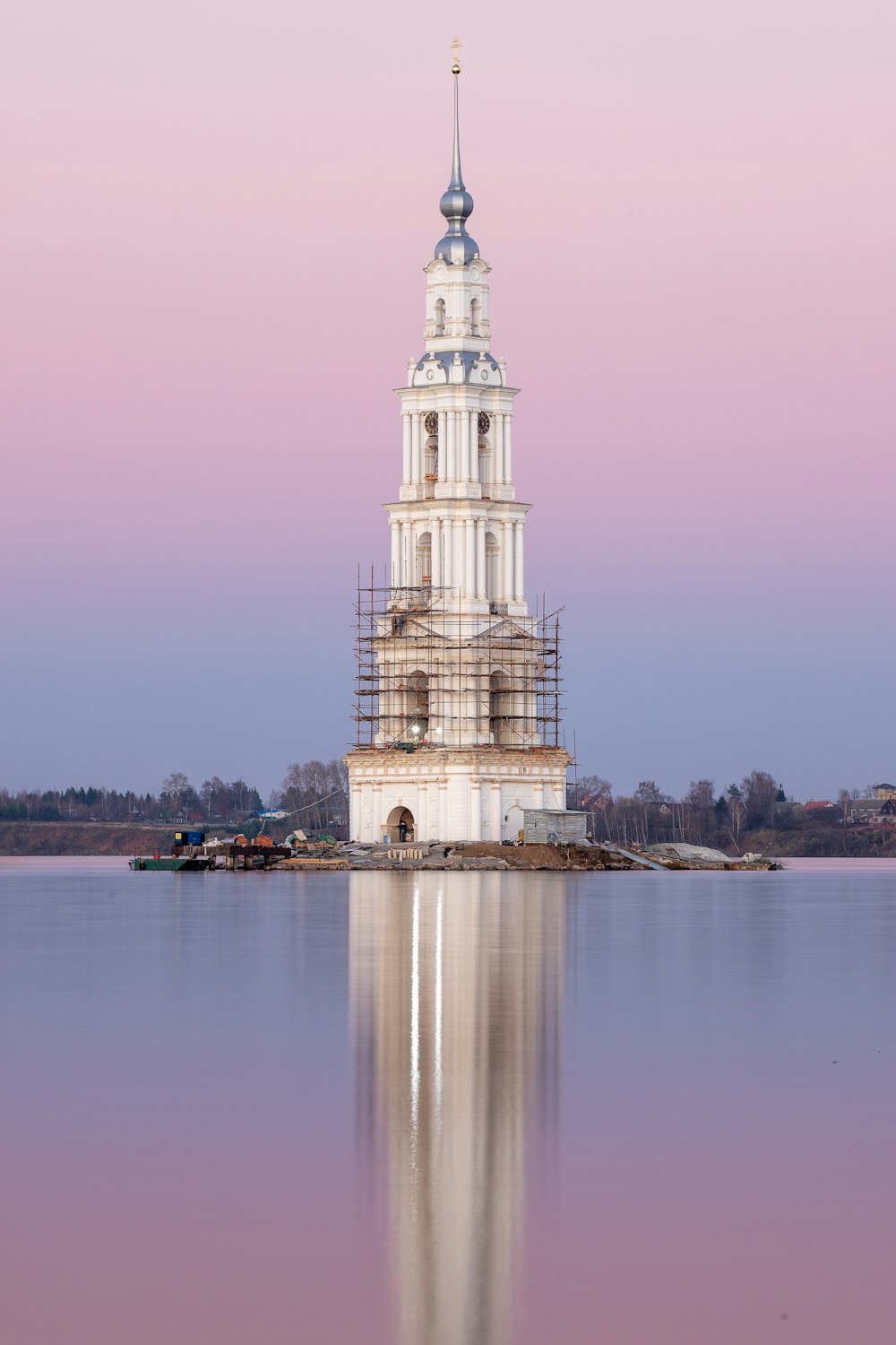 a large white tower with a clock on it's side