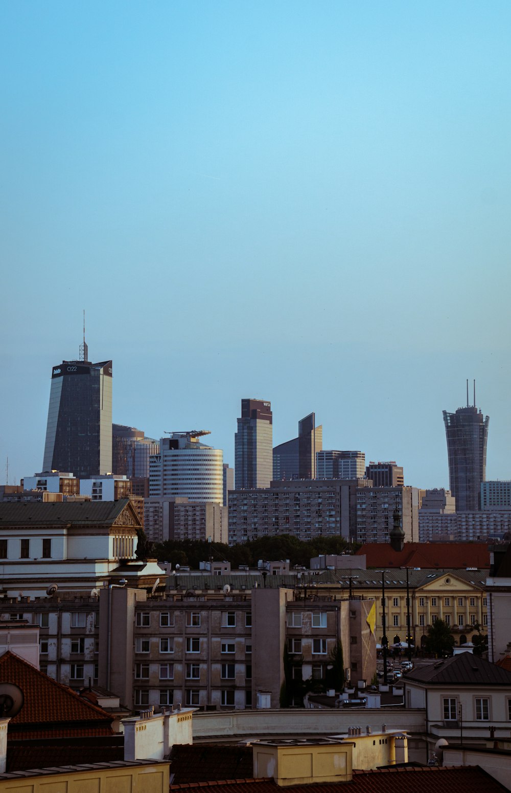 a city skyline with tall buildings and a blue sky