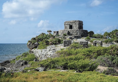 a stone structure on a rocky outcrop near the ocean