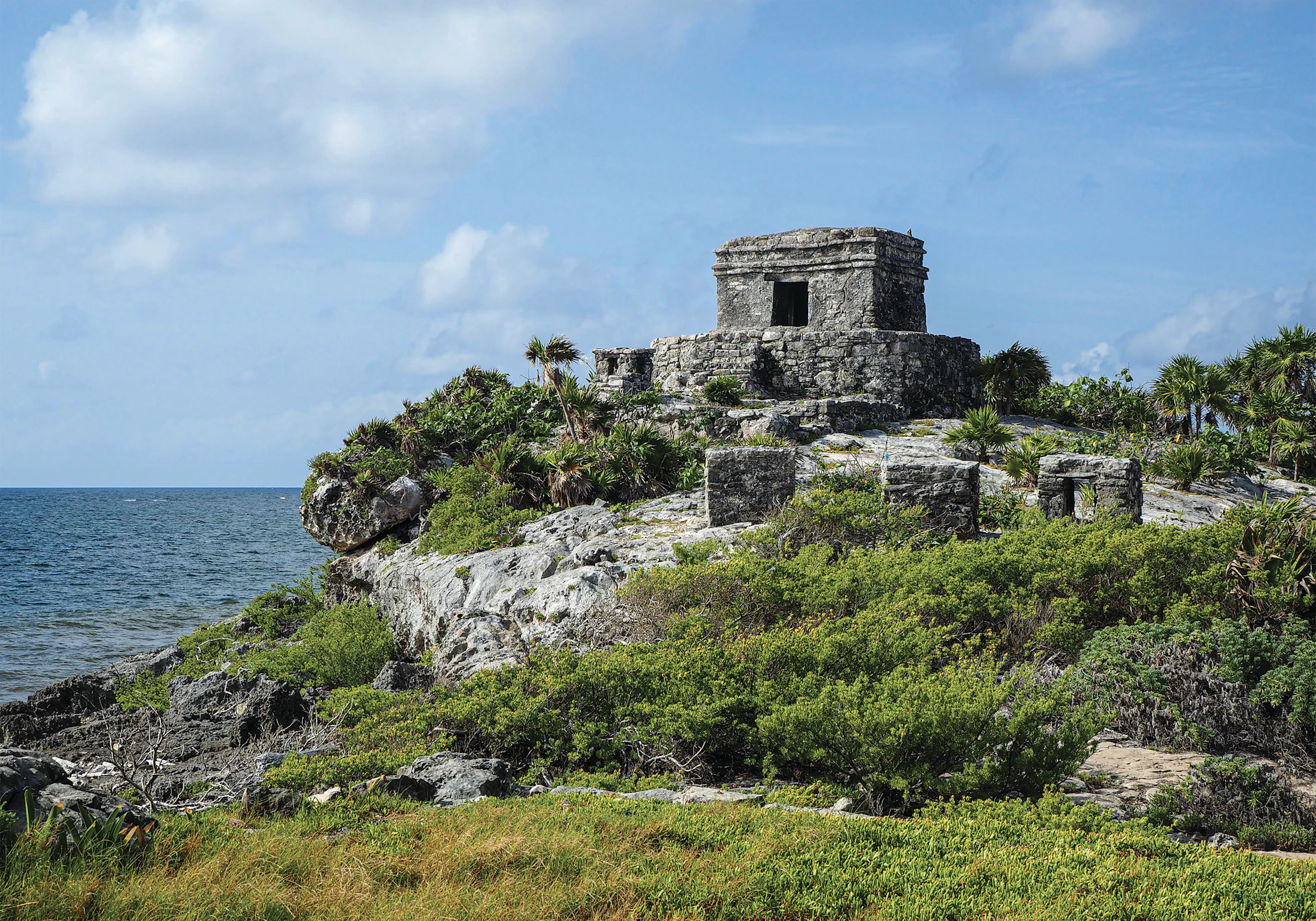 a stone structure on a rocky outcrop near the ocean