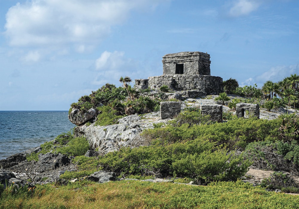 a stone structure on a rocky outcrop near the ocean