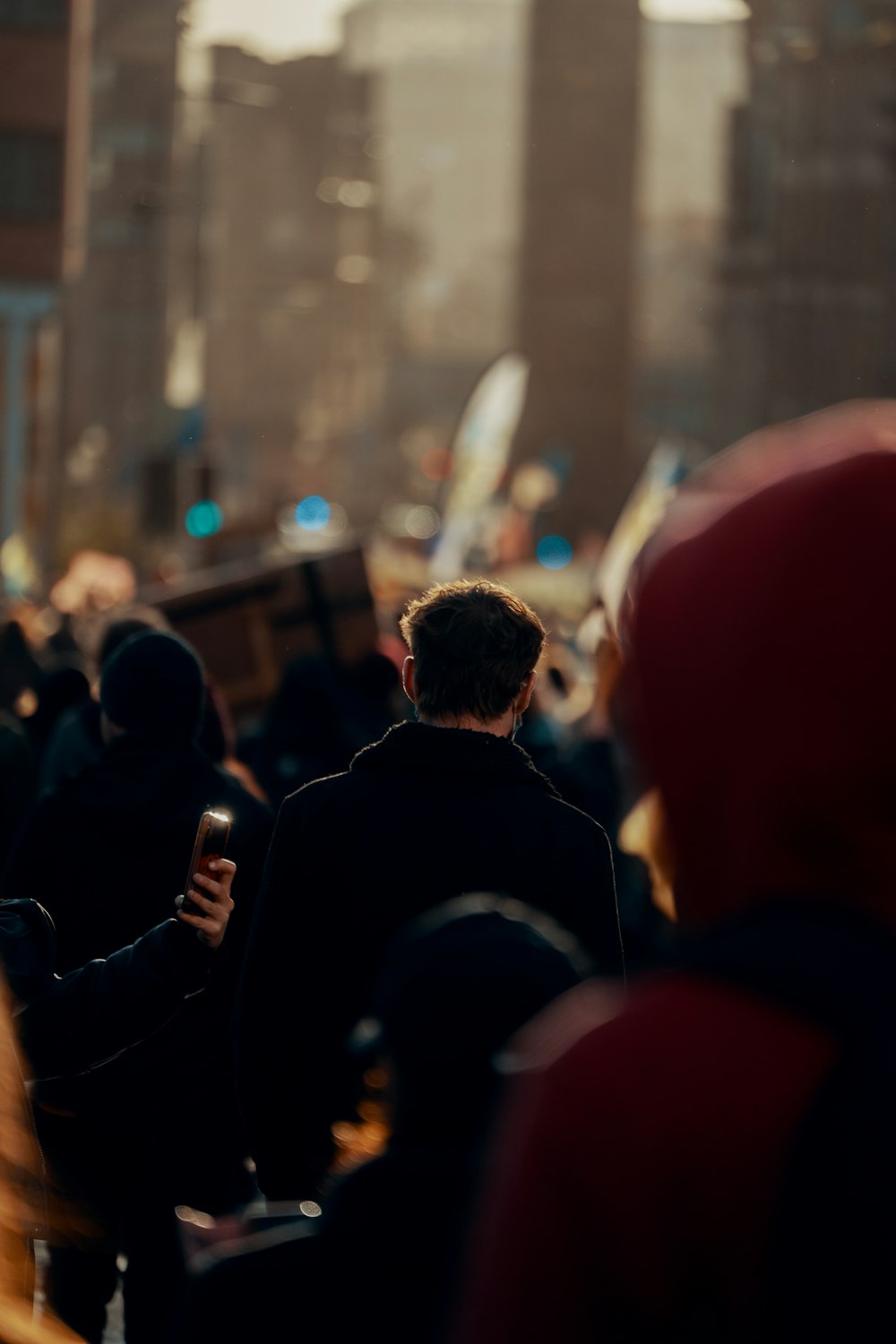 a crowd of people walking down a street next to tall buildings