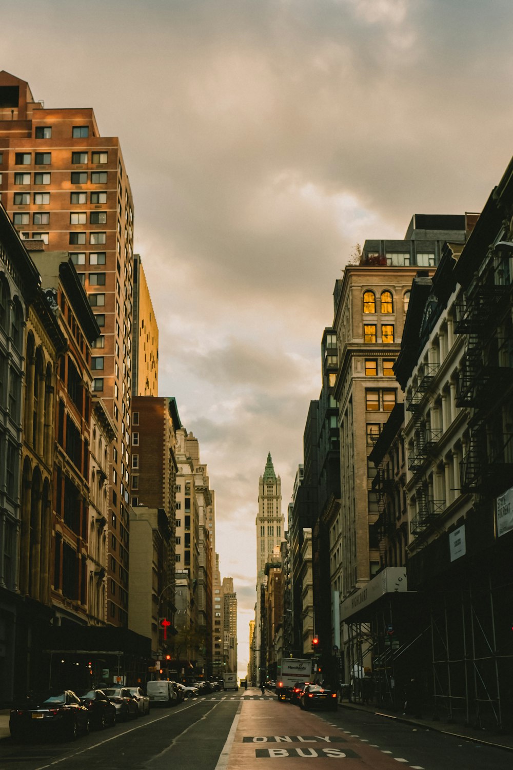 a city street lined with tall buildings under a cloudy sky