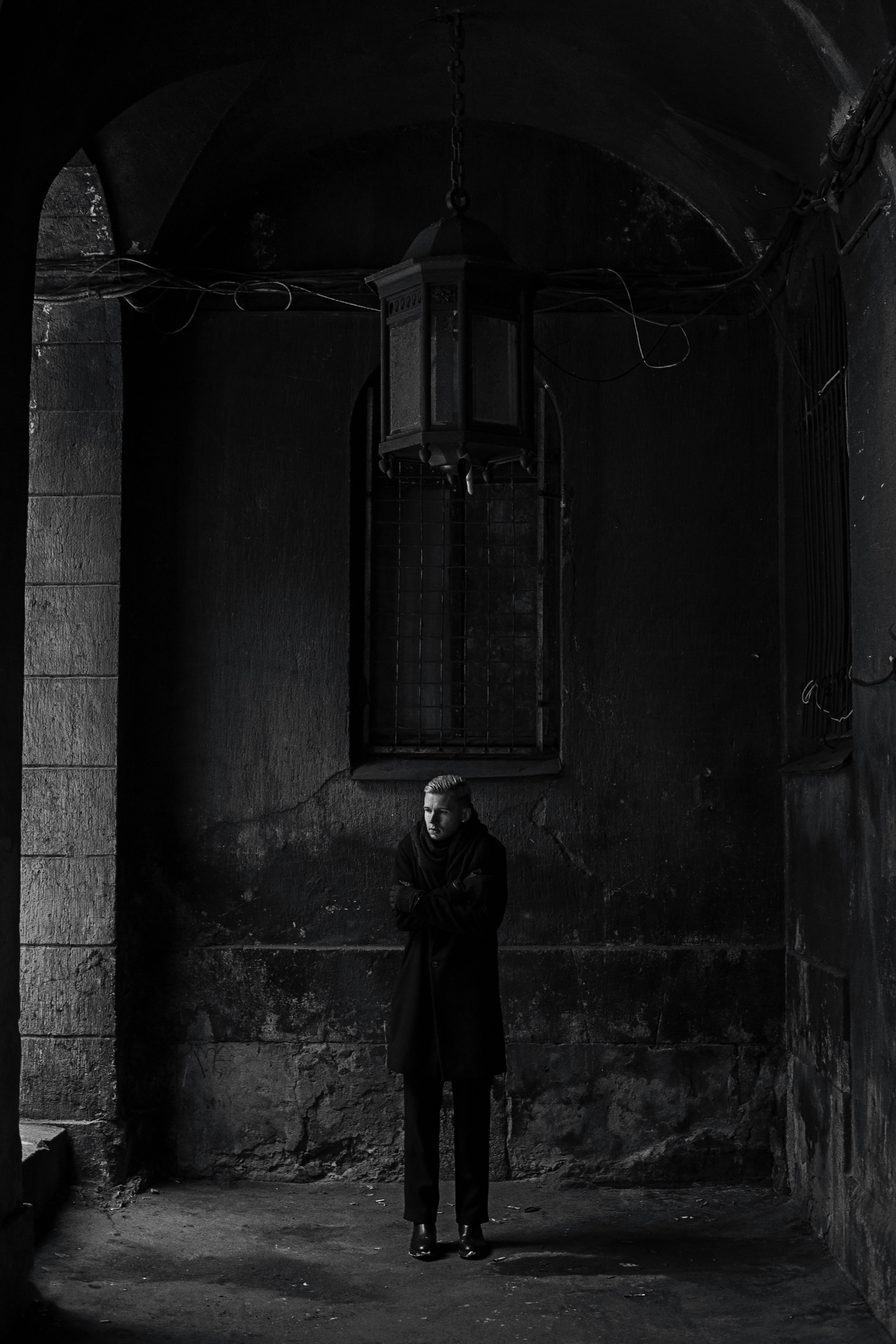 a man standing in a dark room next to a window