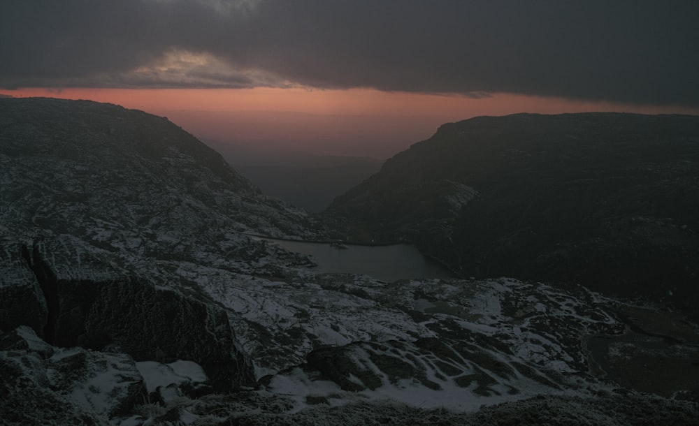 the sun is setting over a mountain range