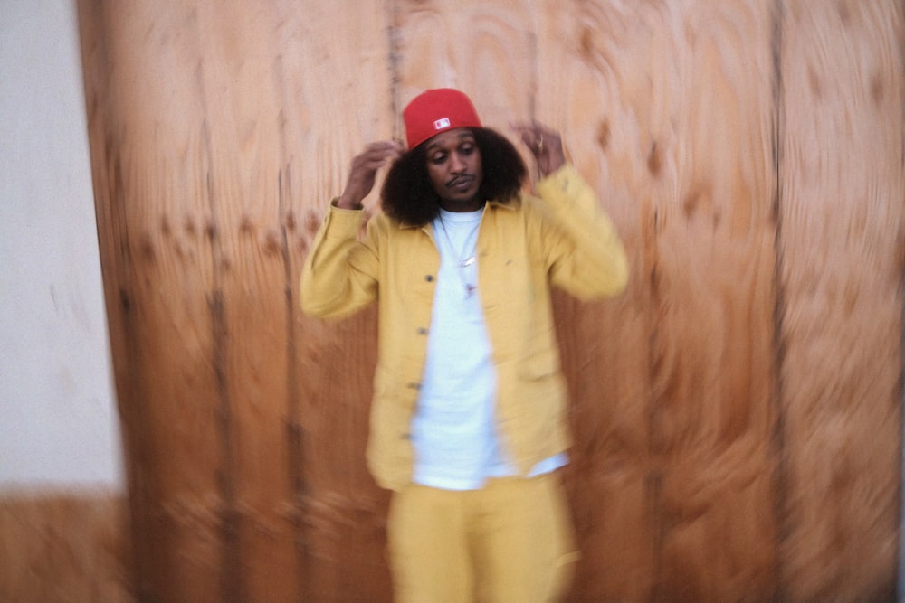 a man in a yellow jacket and red hat