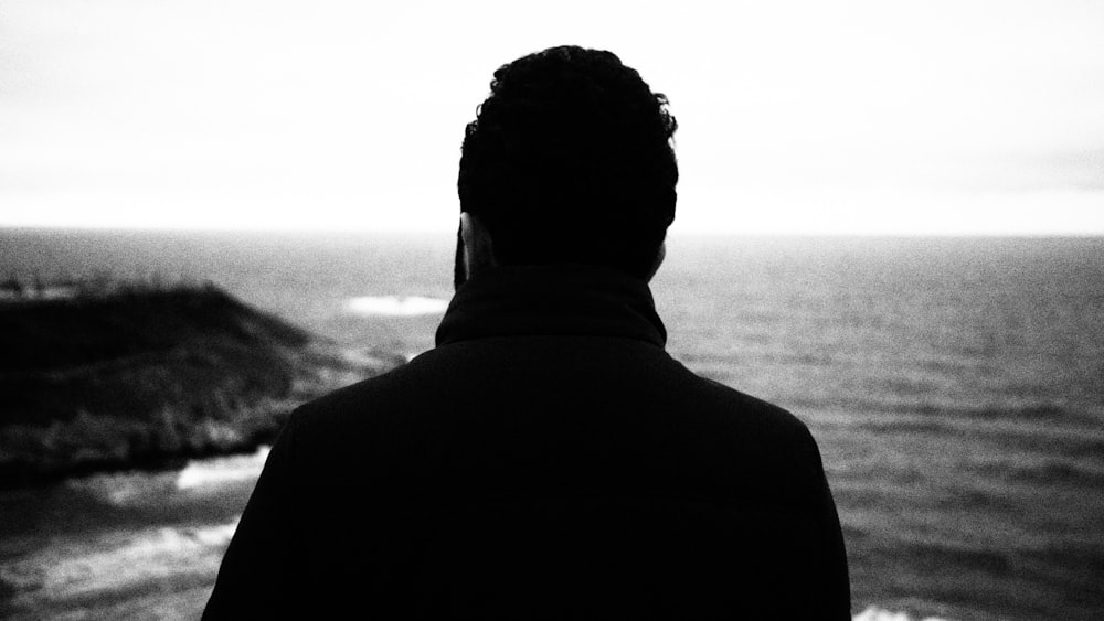 a man standing in front of a body of water