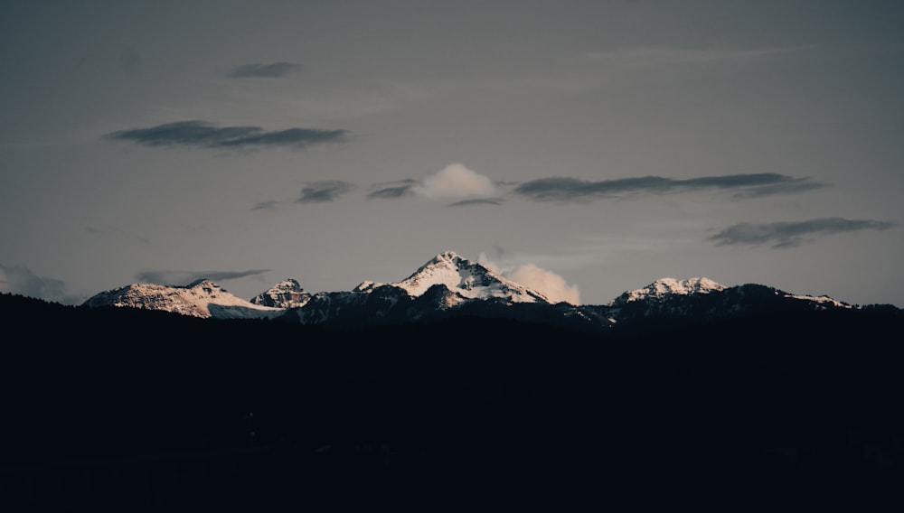 a mountain range with a few clouds in the sky