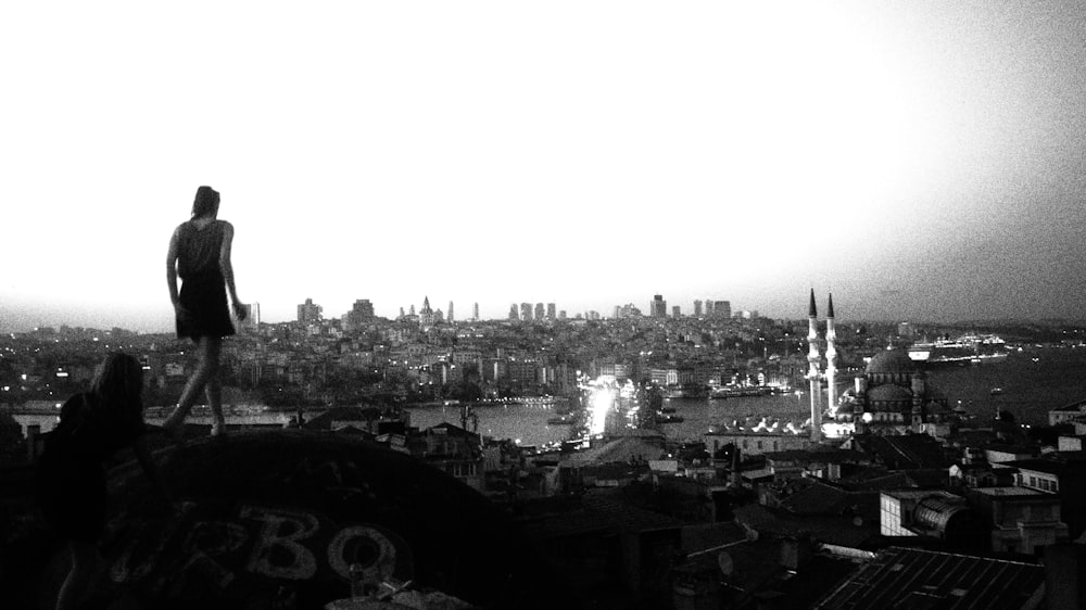 a man standing on top of a hill overlooking a city