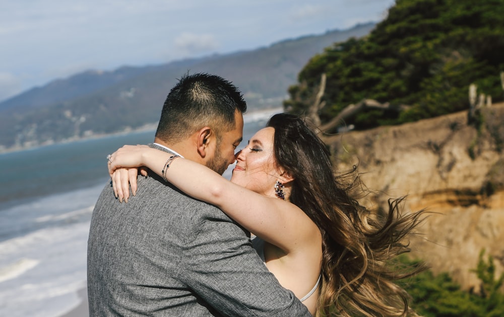 a man and a woman embracing on the beach