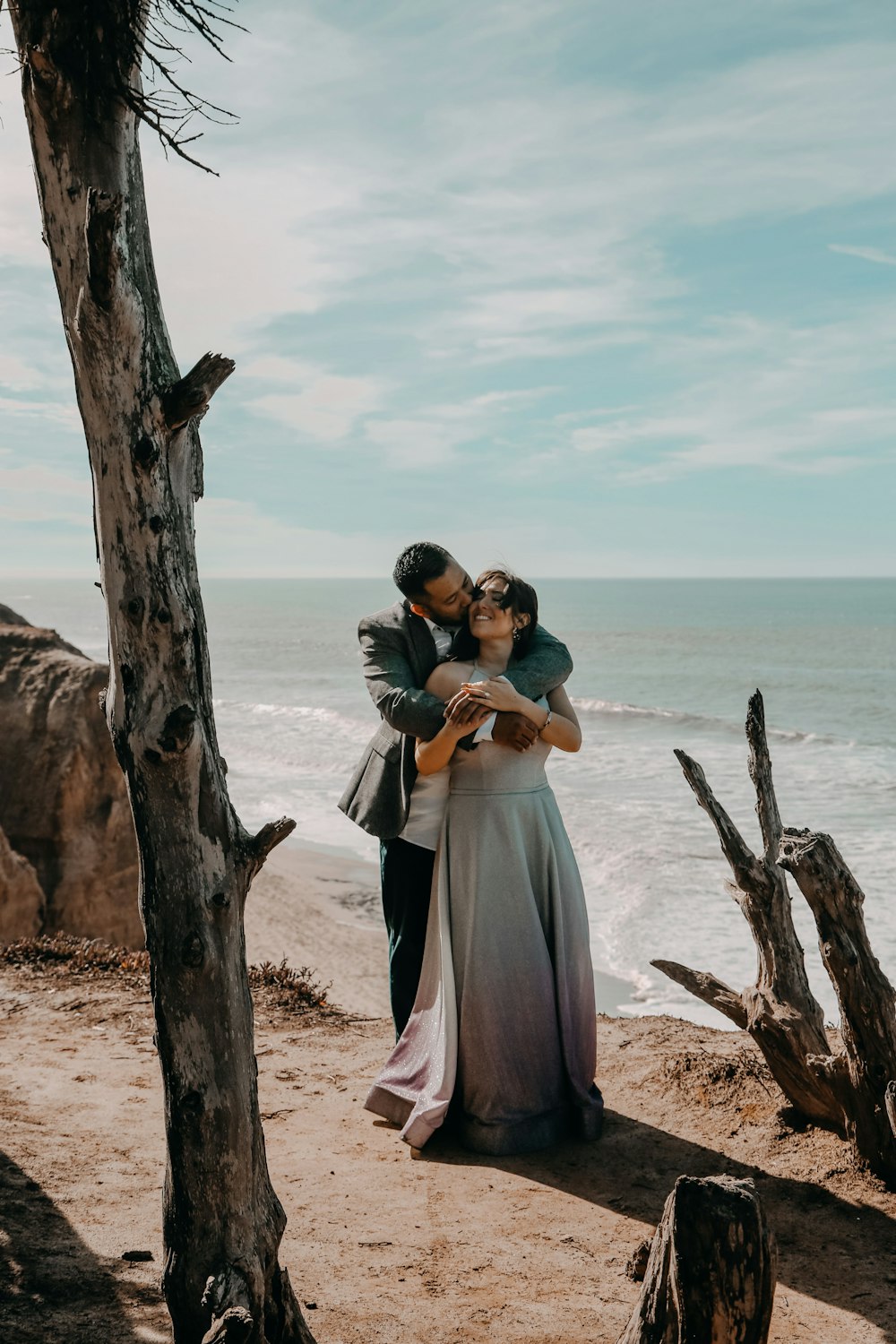 a man and a woman hugging on a beach