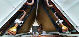 Close-up of copper pipes and capacitors used in refrigeration systems.