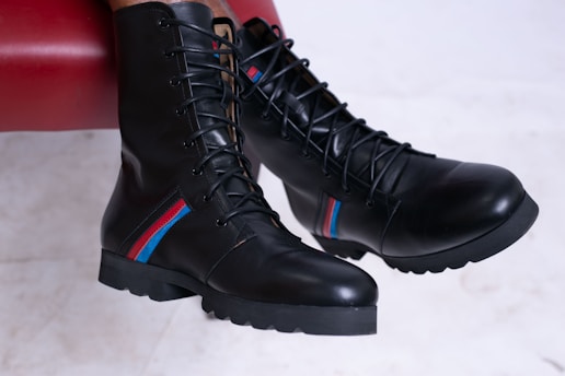 a pair of black boots with red, white, and blue stripes